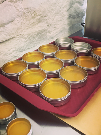 Vegan Wax Co. tin packaging being filled.
